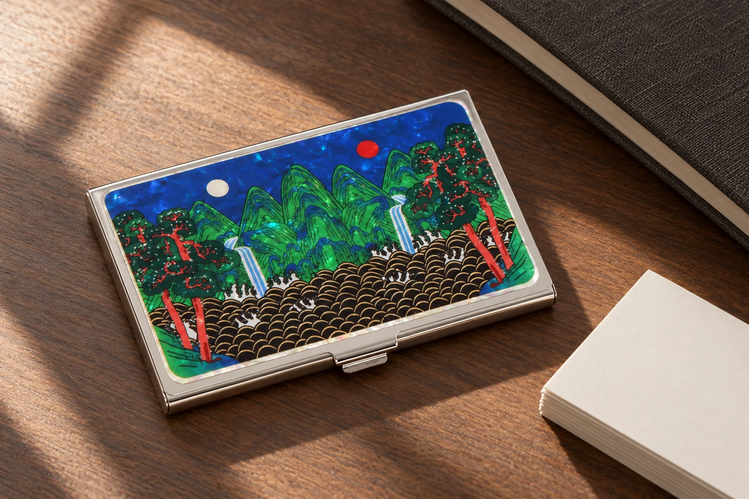Mother-of-pearl card case beside business cards on a walnut desk. Design concept.