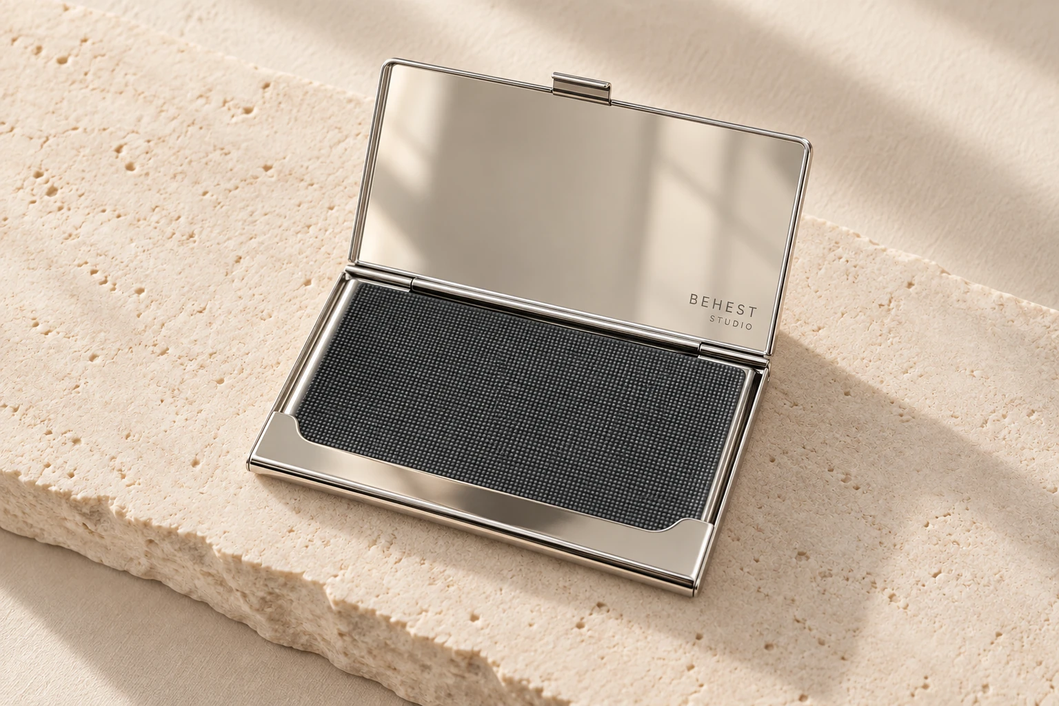 Open card case on a limestone slab, BEHEST STUDIO engraved inside the lid. Design concept.