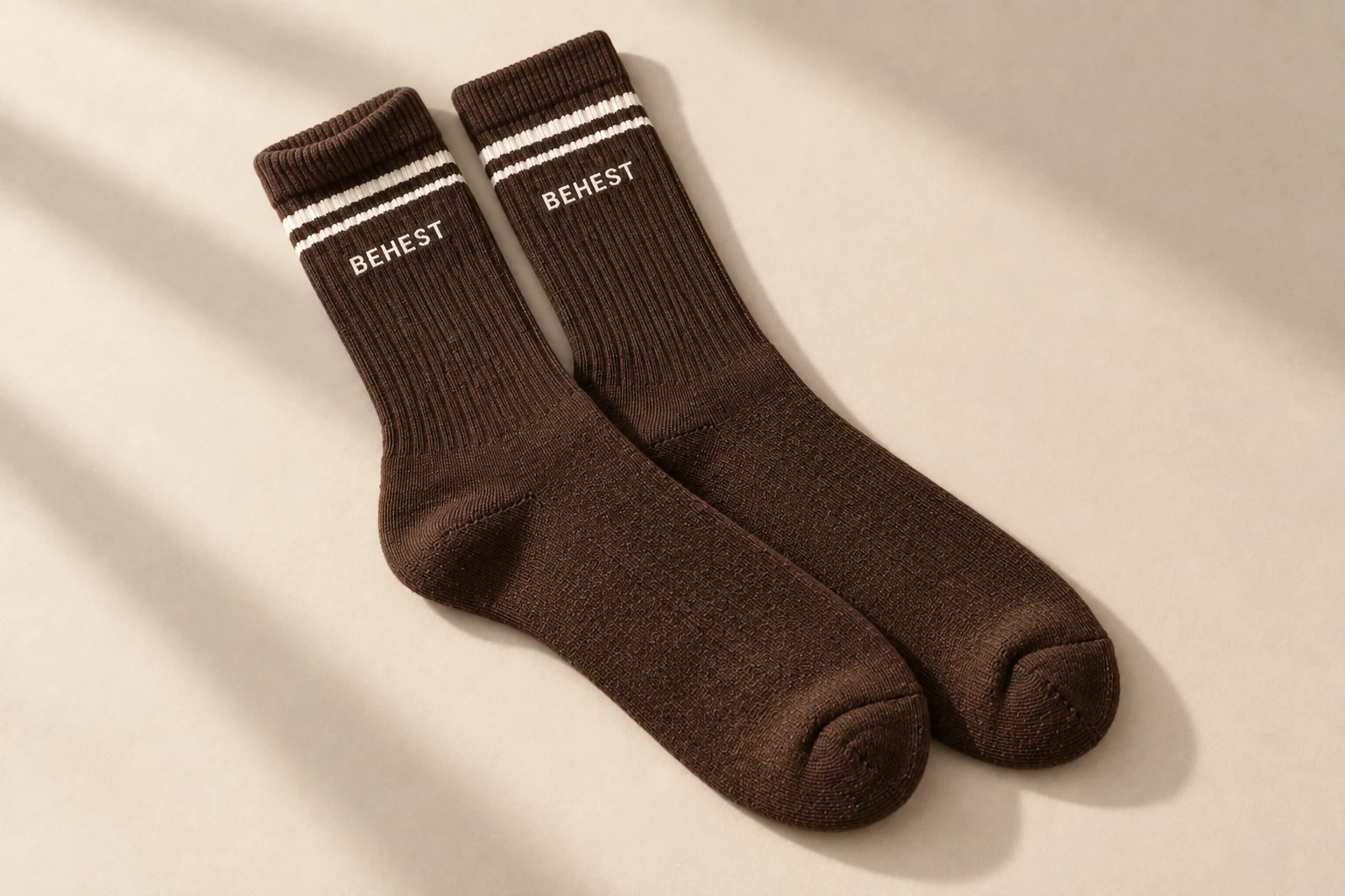 Brown ribbed socks with two cream stripes and a knitted mark.